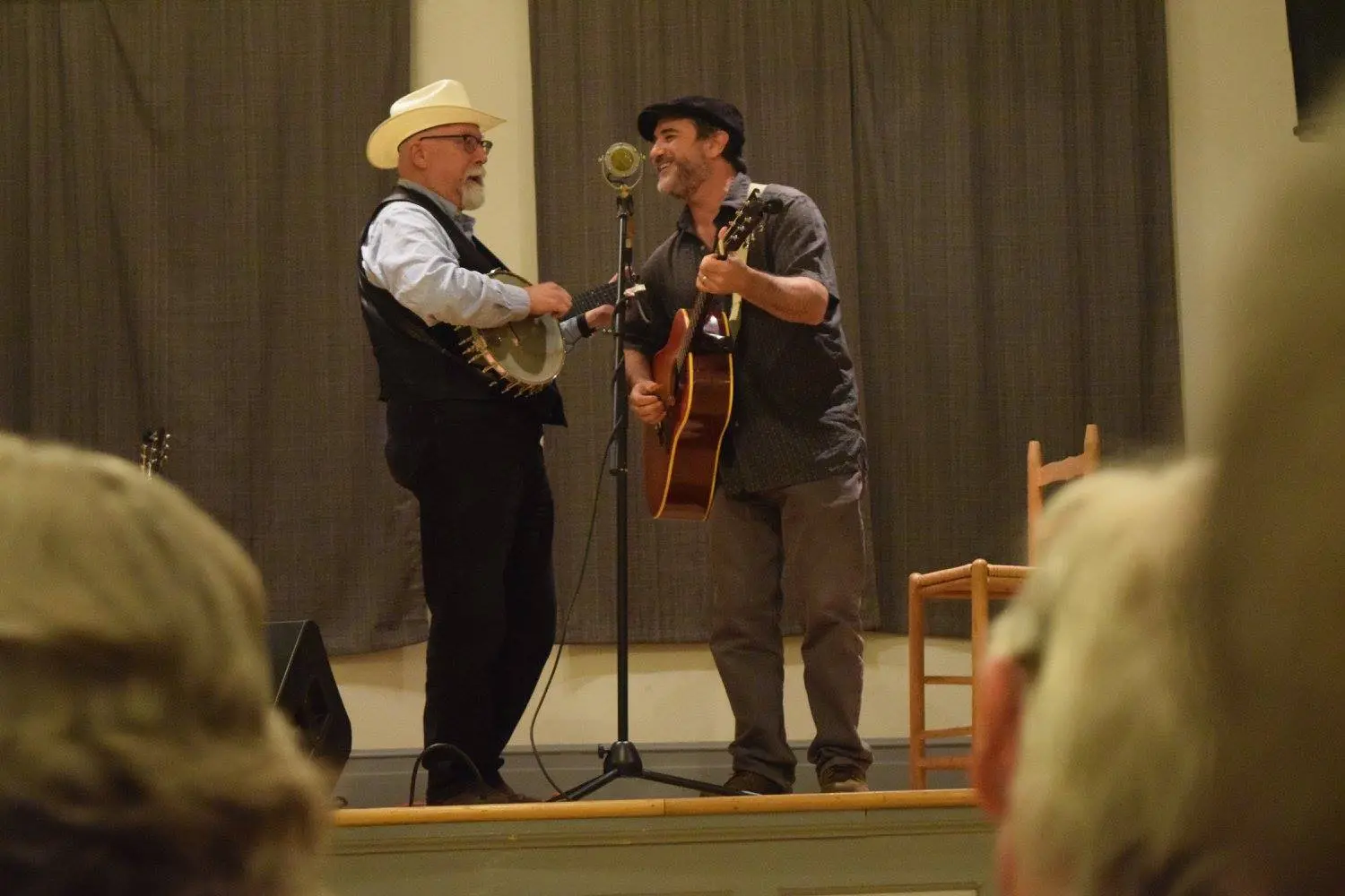 Two men are performing on stage with a microphone.